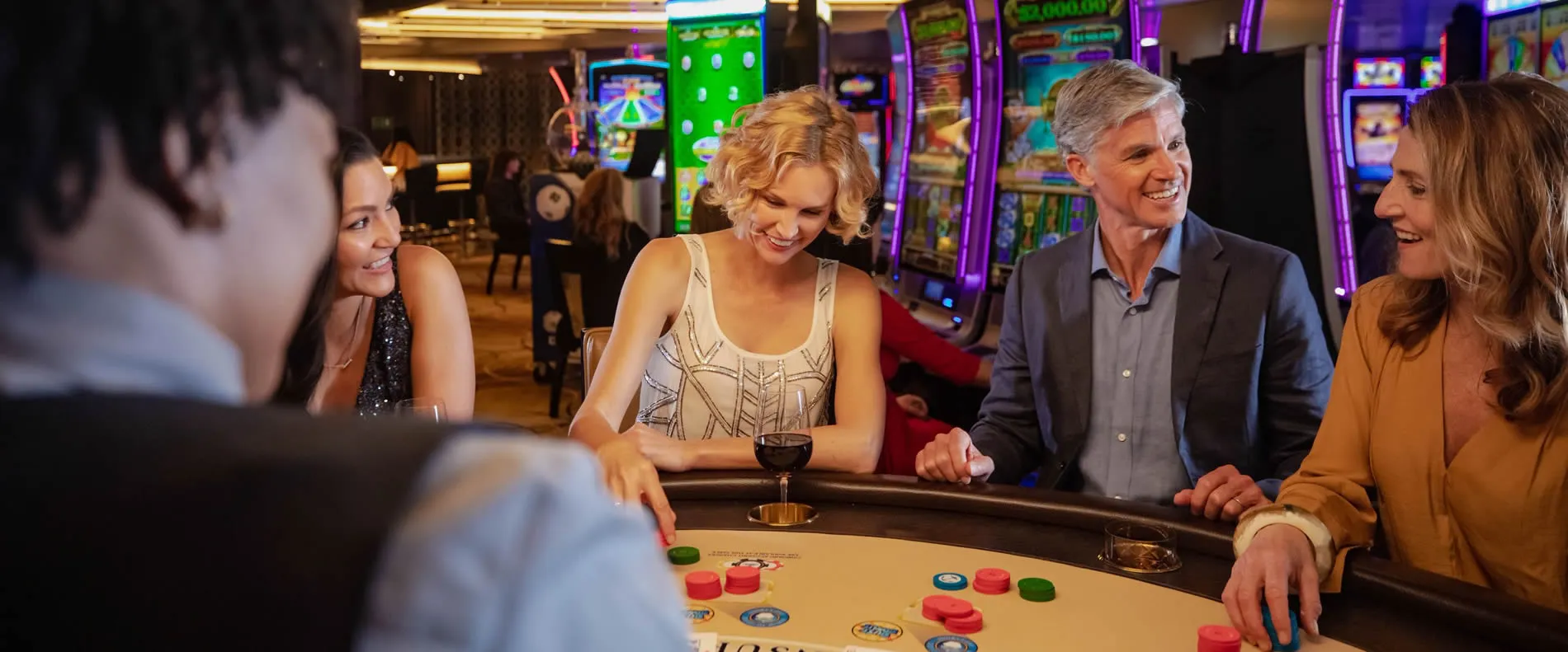 Friends enjoying game night at colorful casino with roulette table