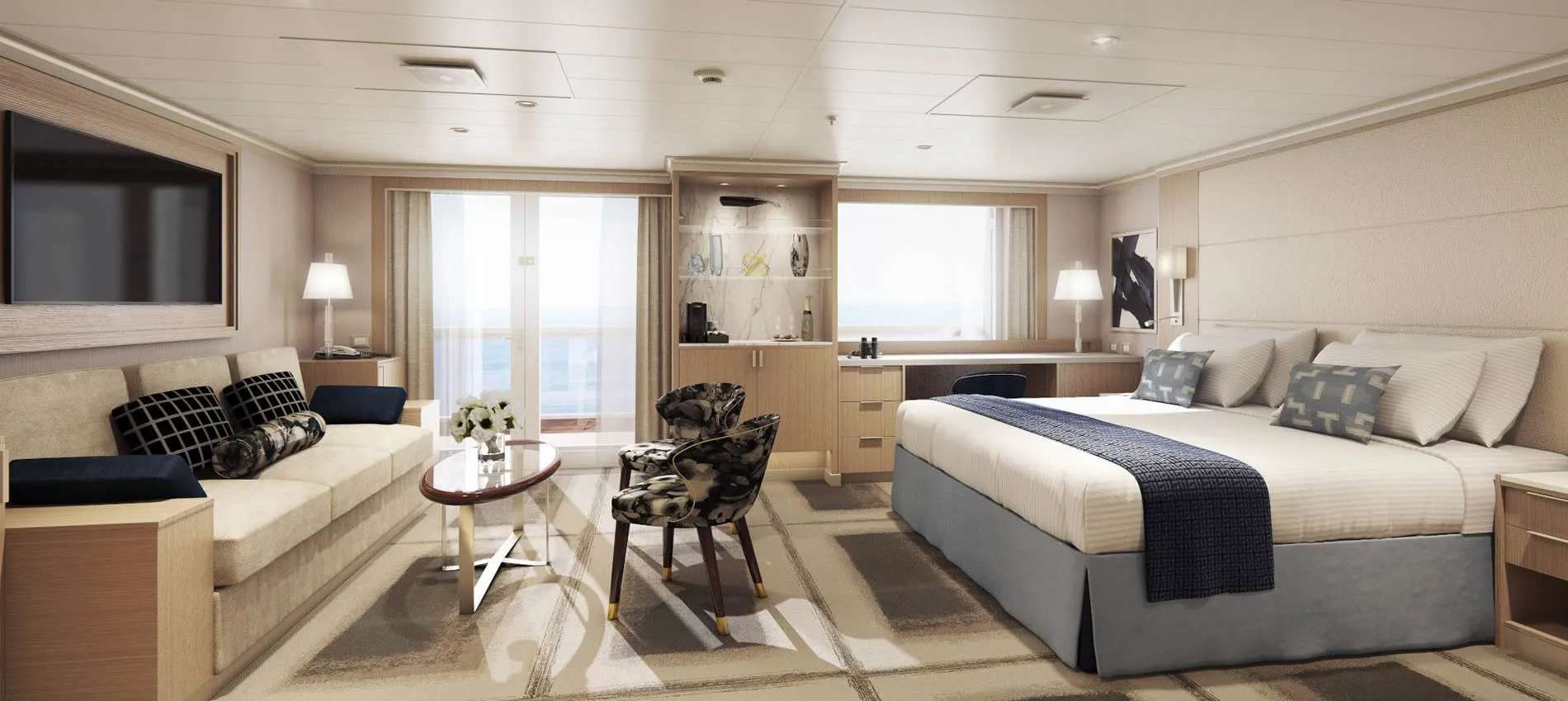Luxury cruise ship cabin with bed, sitting area, and ocean view