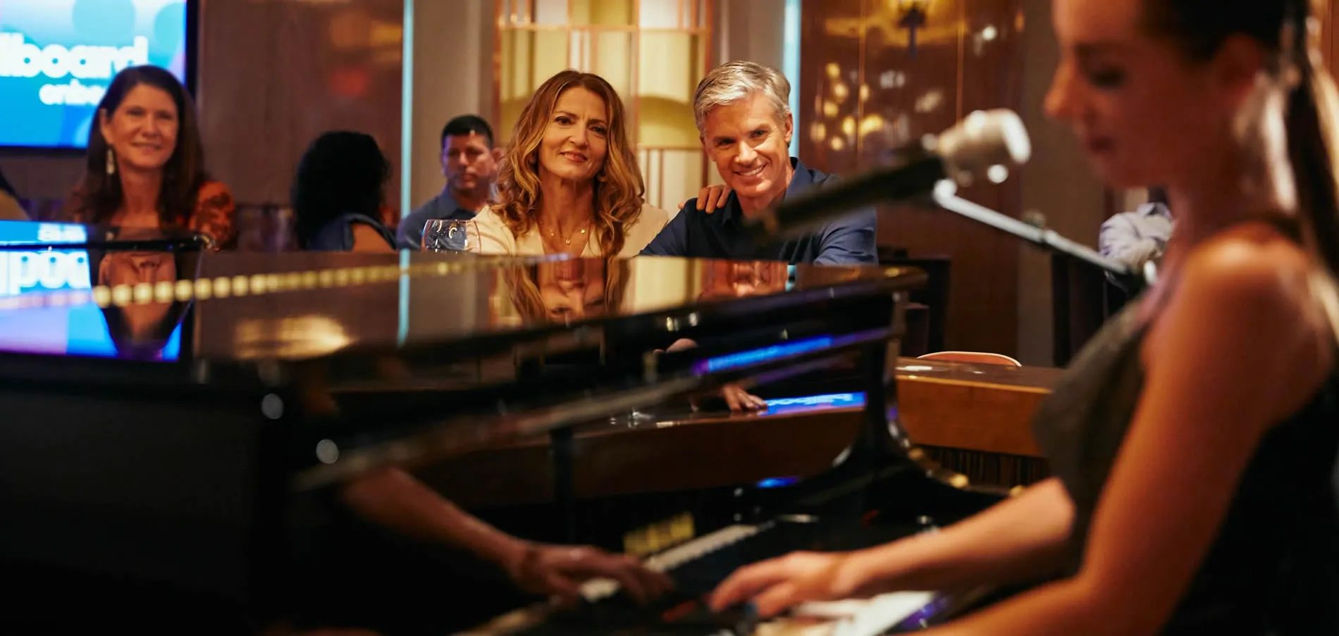 Group of people smiling in a studio with musical instruments