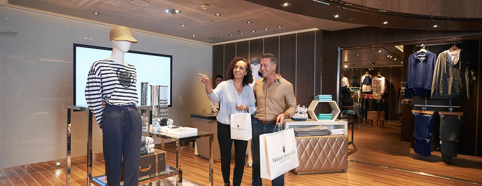 Customers shopping in a stylish clothing store with mannequin and displays