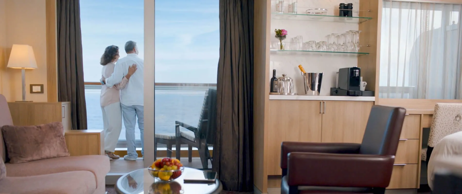 Couple enjoying ocean view from balcony in modern hotel room