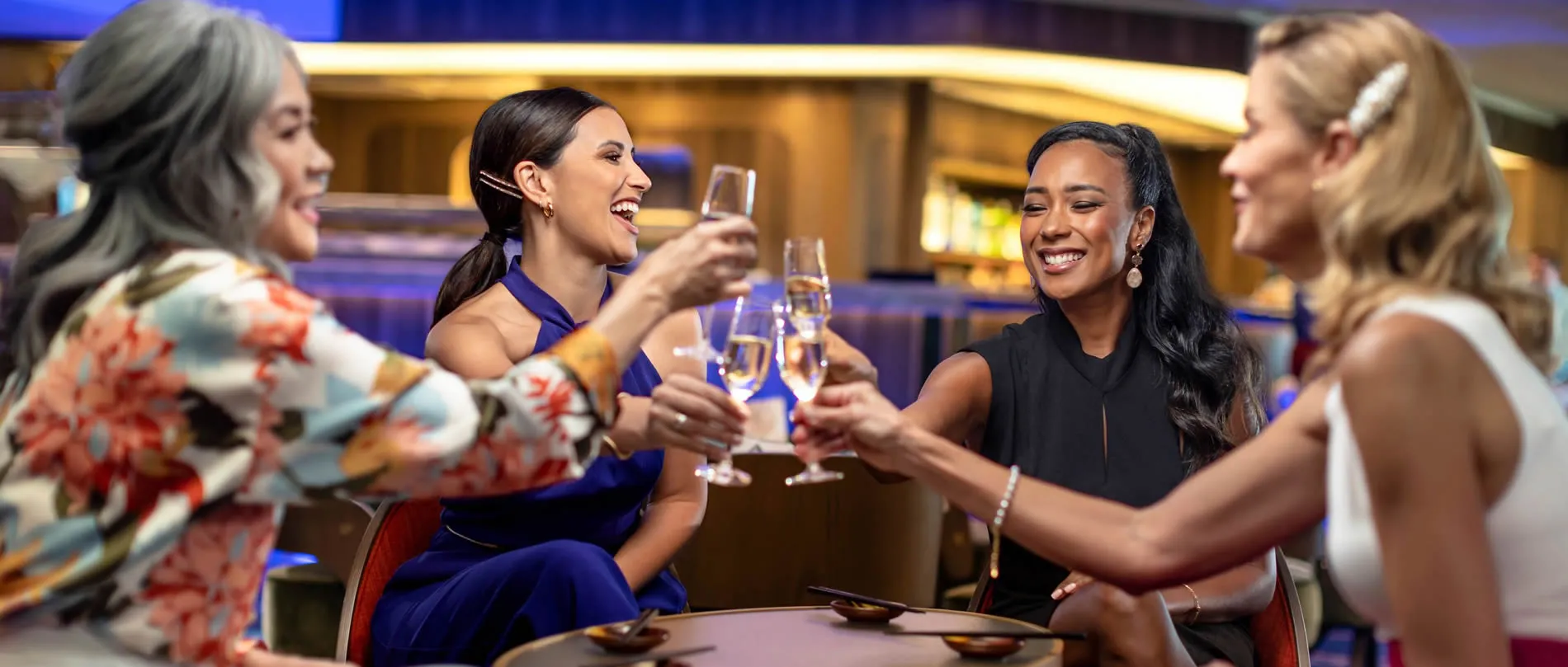 Women toasting champagne glasses and laughing together at elegant event
