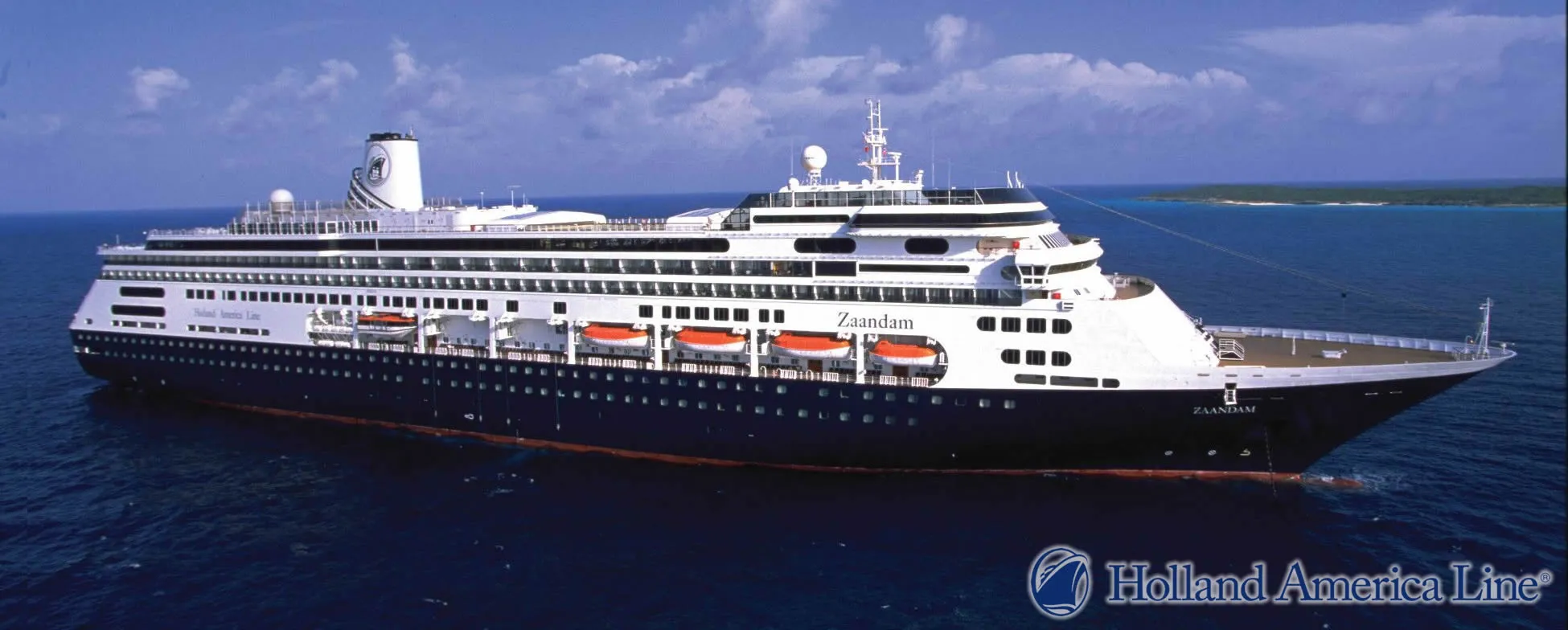 Zaandam cruise ship sailing on blue ocean with land in background