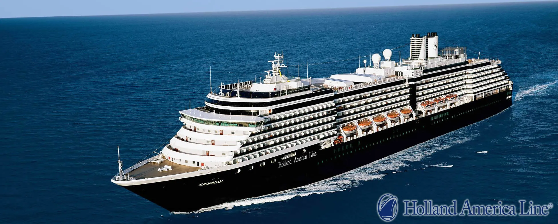 Large Holland America cruise ship sailing on deep blue ocean