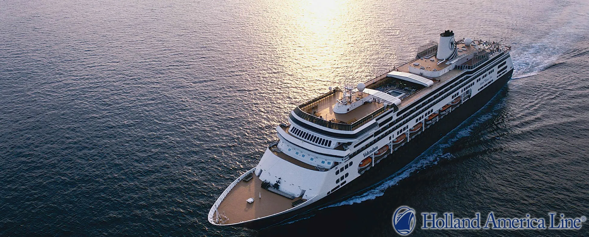 Holland America Line cruise ship sailing on ocean at golden sunset