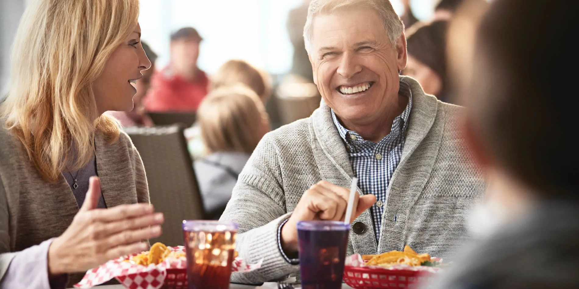 Smiling older man and woman enjoying lunch together in casual restaurant