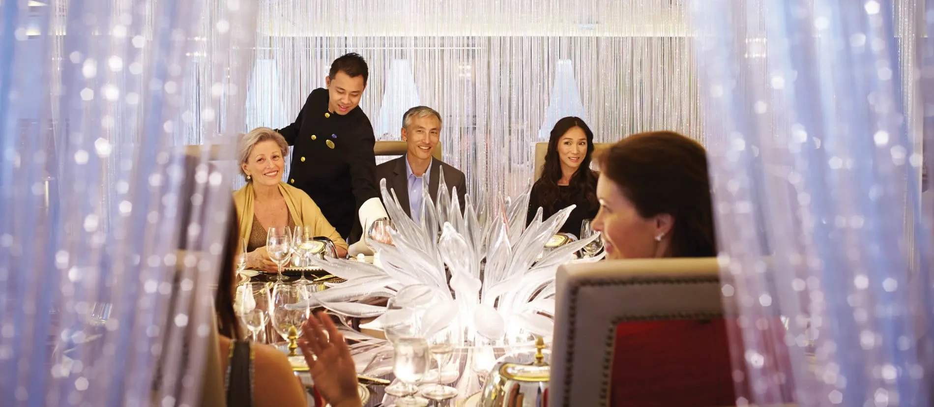 Elegant dinner party with sparkling decor and guests at beautifully set table