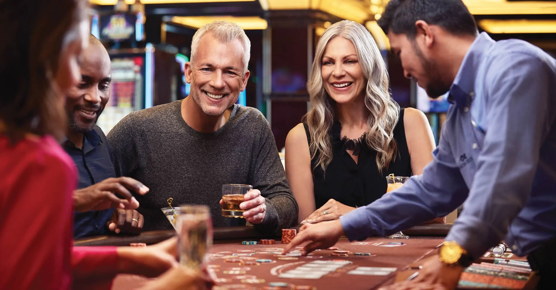 Friends enjoying drinks and gambling together at a casino table
