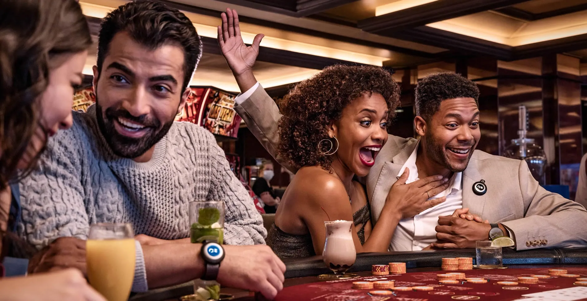 Friends excited at casino table with drinks and gambling chips
