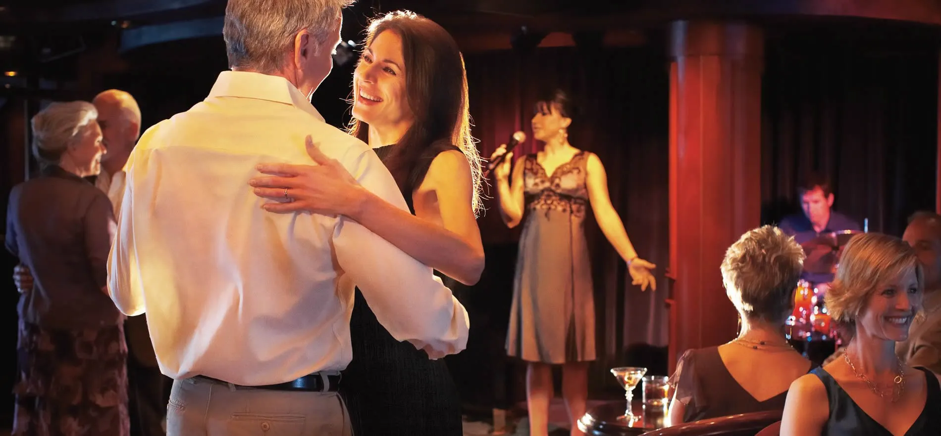 Couple dancing at elegant venue with live music and other patrons