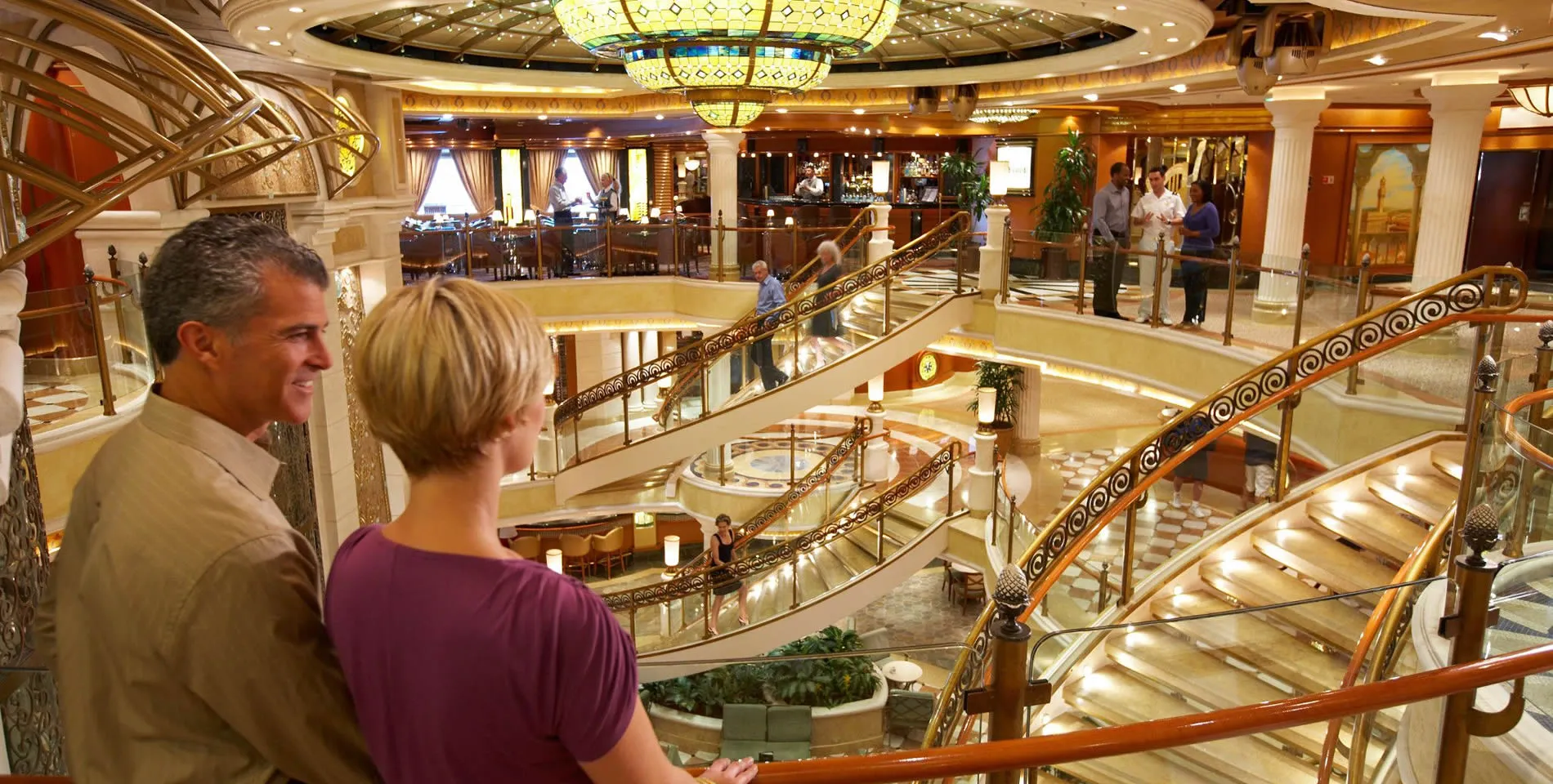 Luxurious cruise ship interior with grand multi-level atrium and ornate stairs