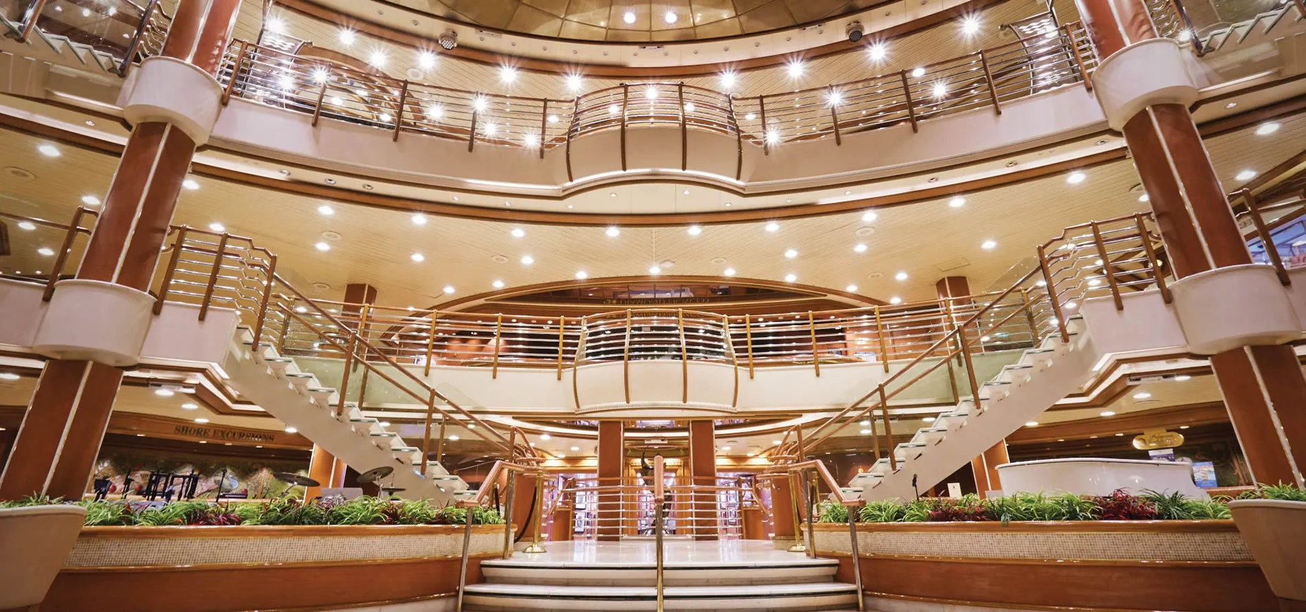 Luxurious multi-level cruise ship atrium with elegant lighting and staircases