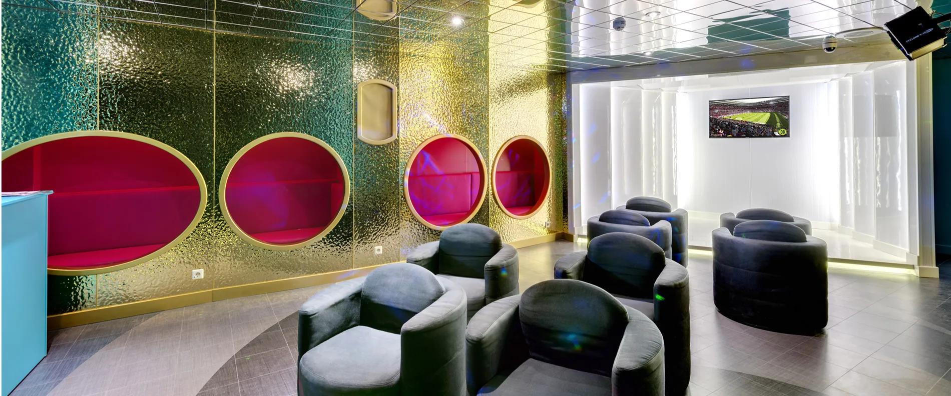 Modern lounge with colorful porthole windows and gray chairs