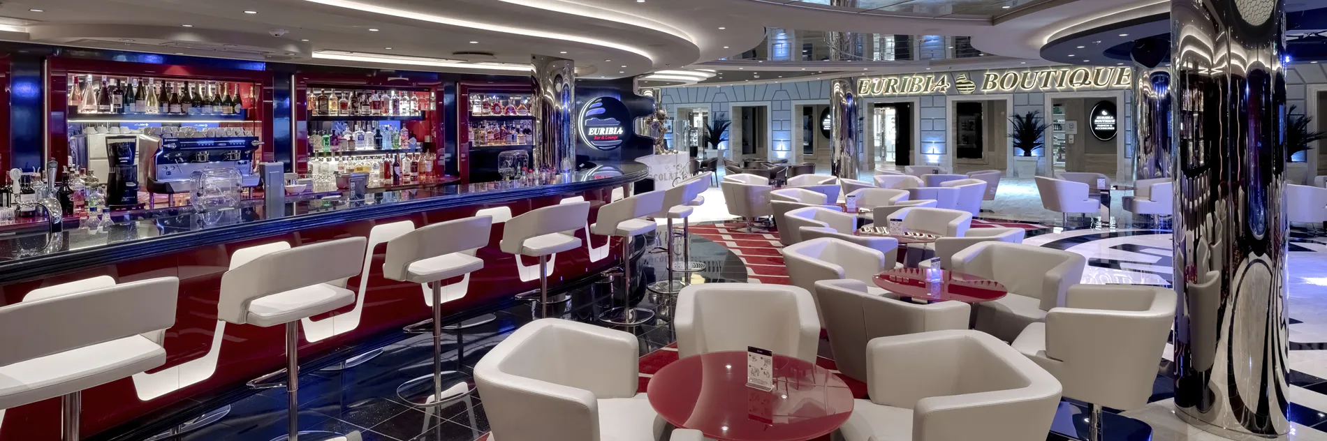 Modern cruise ship bar with white chairs, blue lighting, and fully stocked liquor shelves