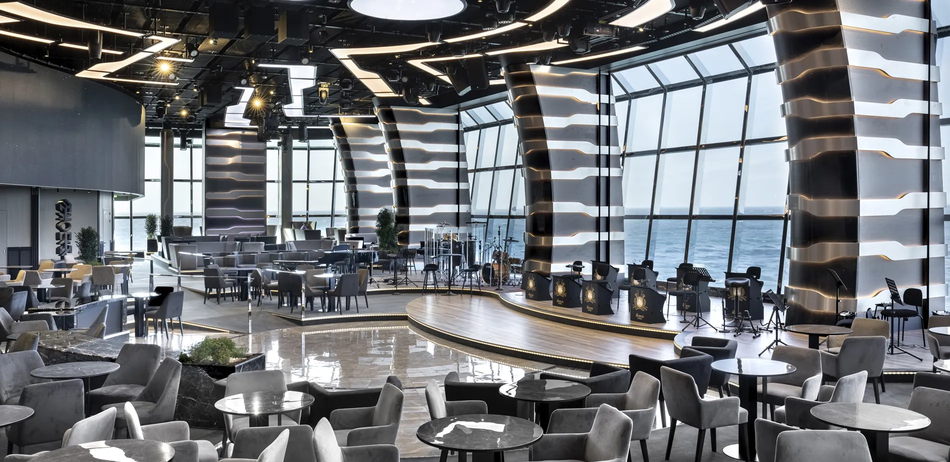 Modern seaside venue with curved design, ocean view, and elevated stage