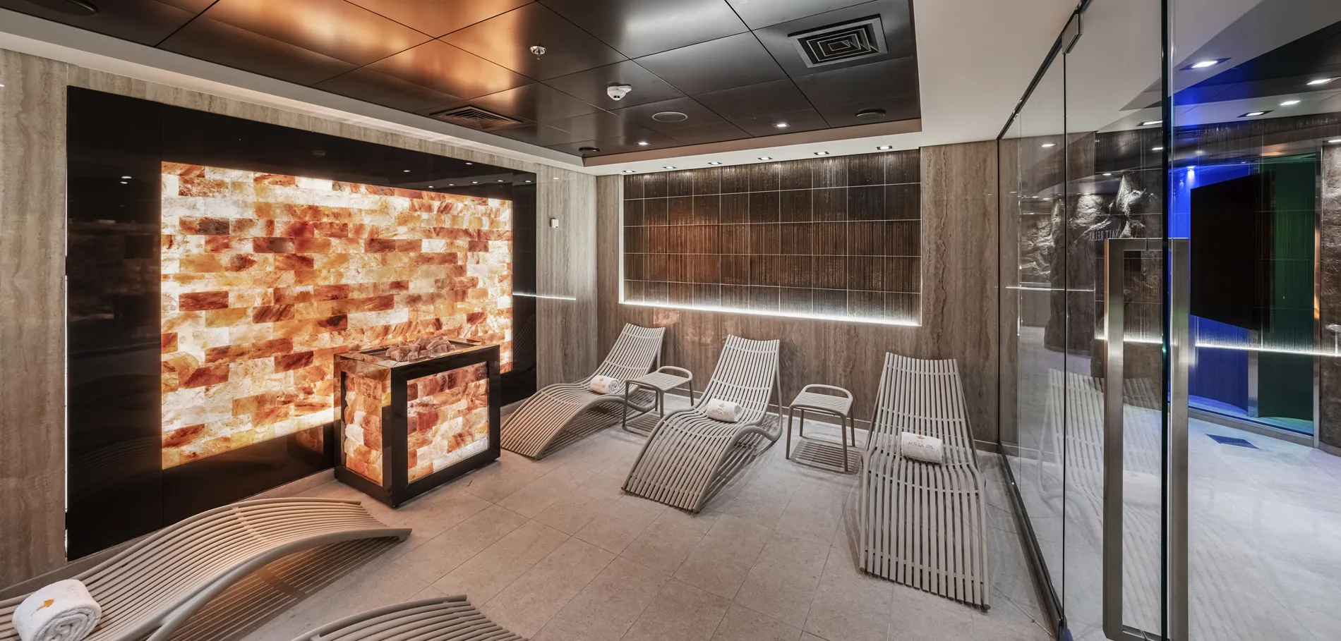Modern salt room with illuminated himalayan salt wall and relaxation chairs