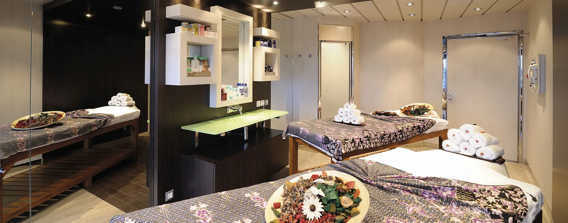 Modern spa treatment room with massage beds and decorative plates