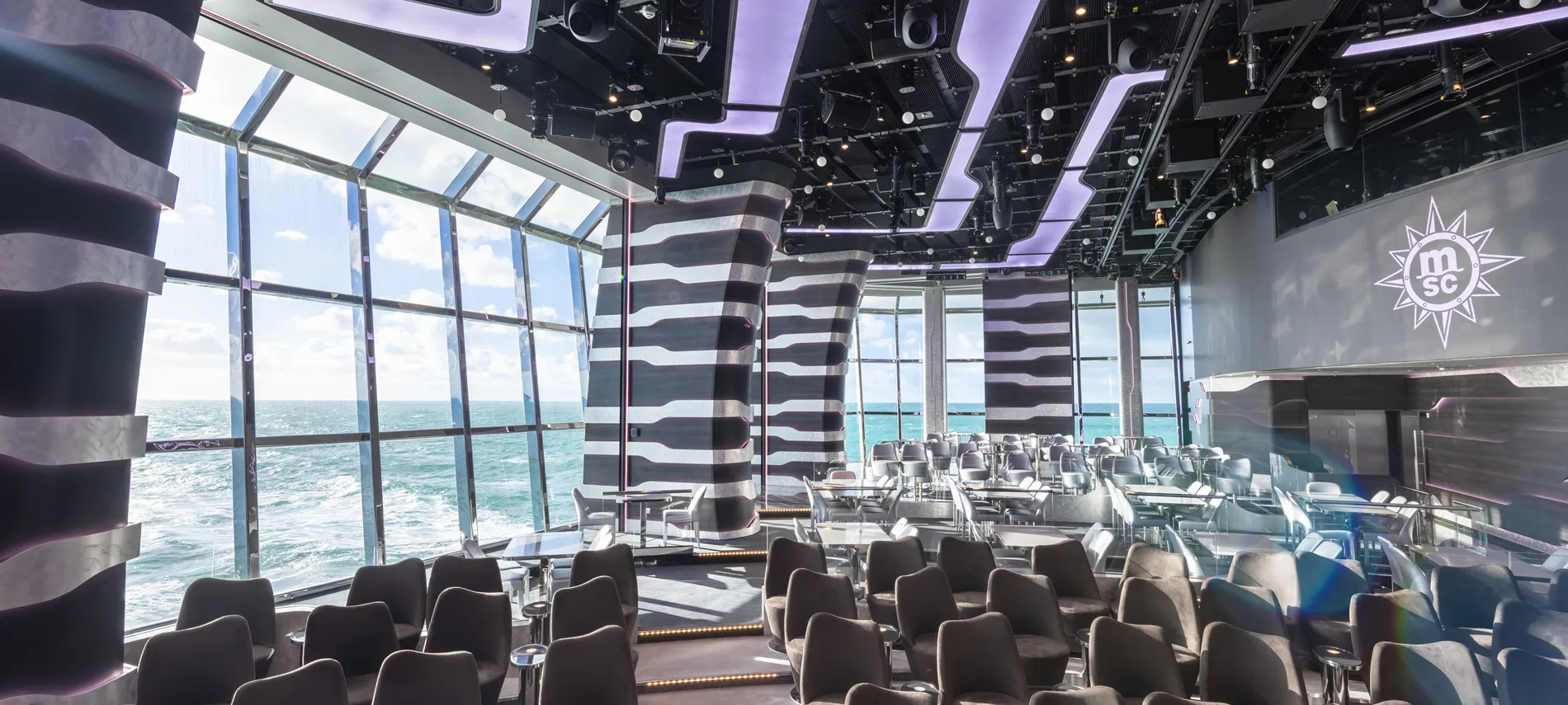 Modern cruise ship lounge with panoramic ocean view and stylish seating