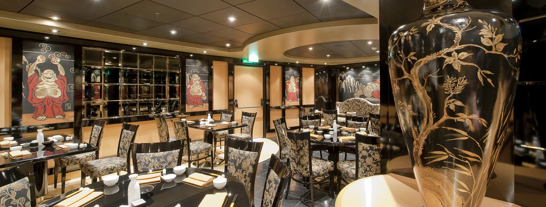 Elegant Asian restaurant interior with Buddha artwork and decorative vase