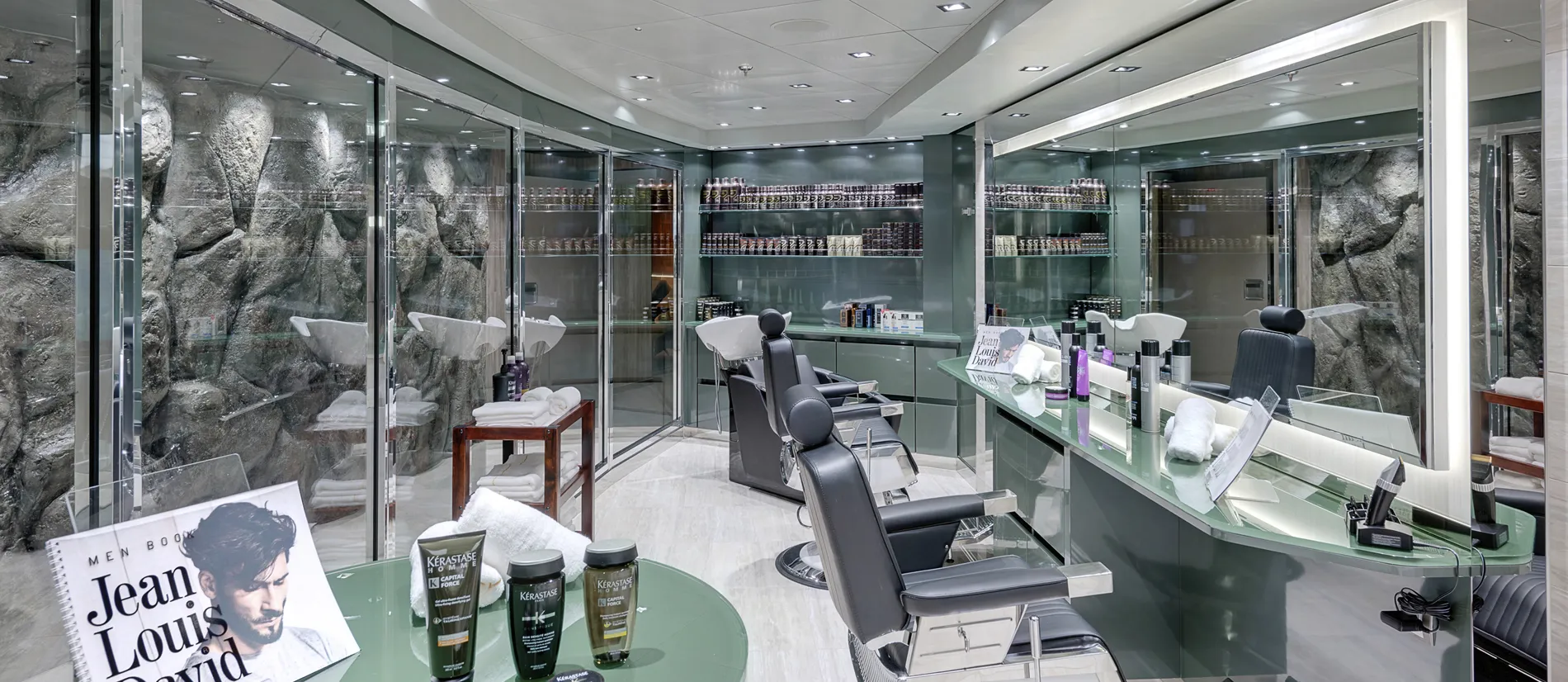 Modern hair salon with glass walls, rock-like backdrop, and styling products