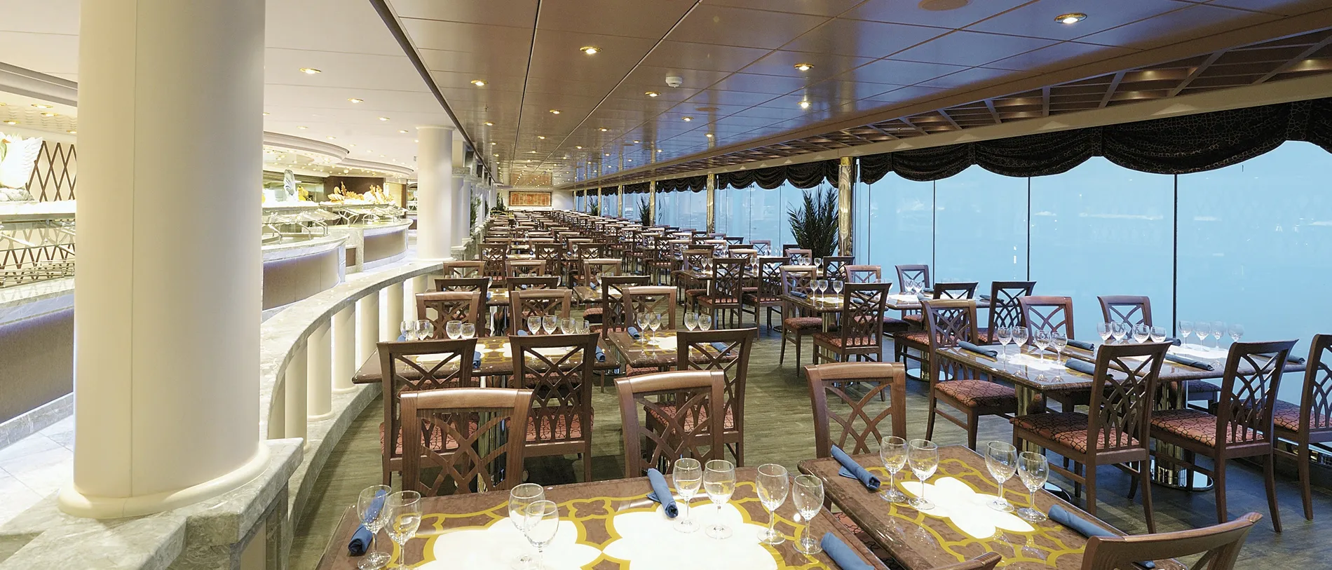 Elegant cruise ship dining room with ocean view and prepared tables