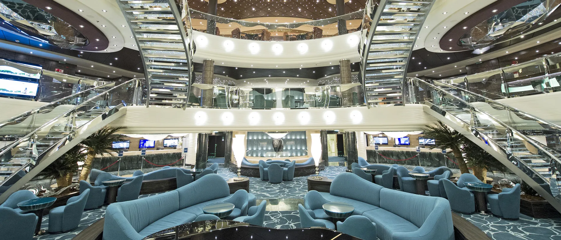 Luxurious multi-level cruise ship interior with blue seating and starry ceiling