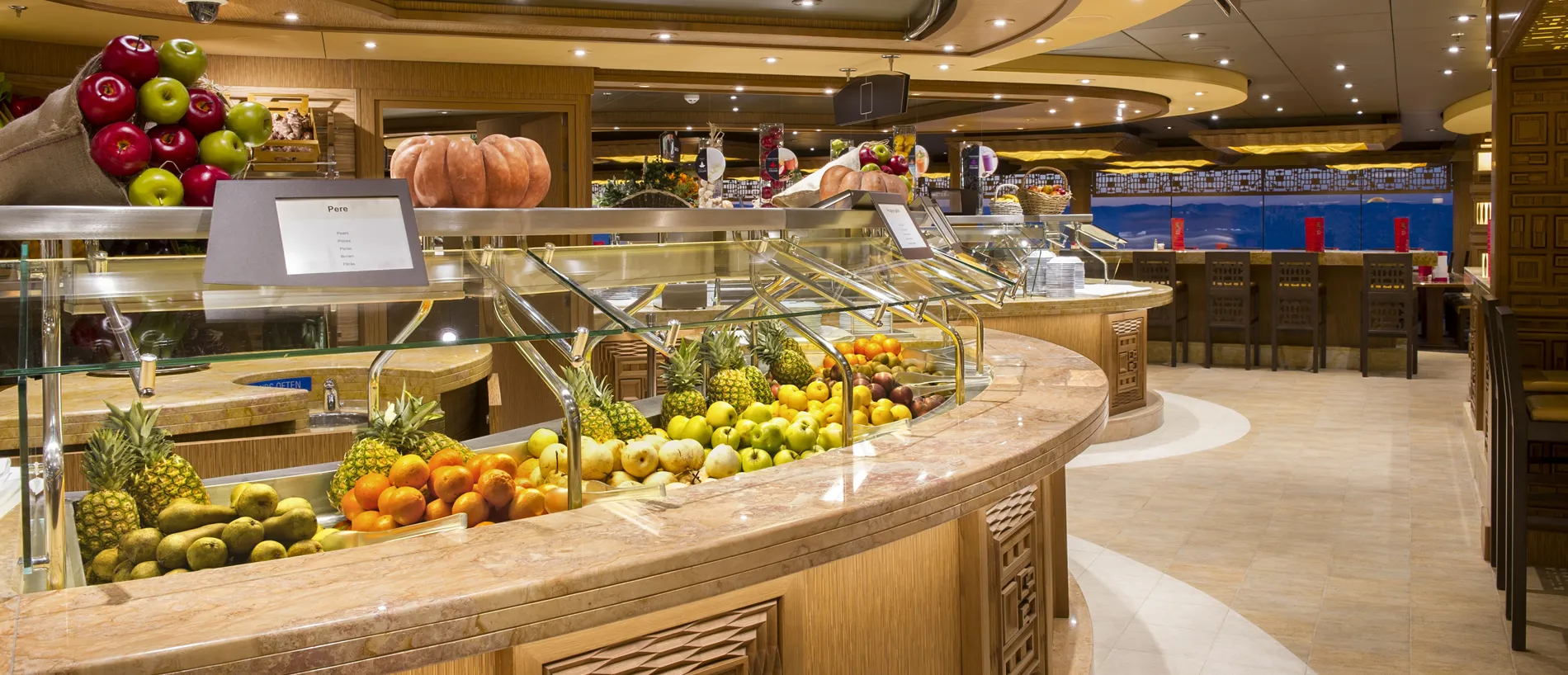 Curved fruit buffet with colorful produce in elegant restaurant setting