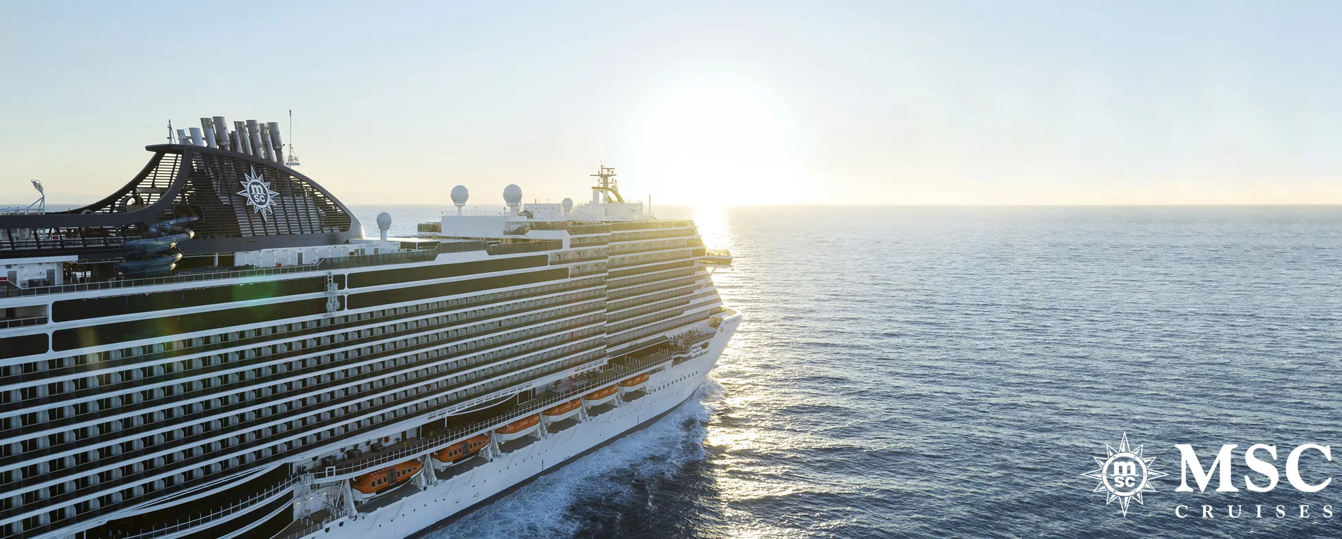 Large MSC cruise ship sailing on calm ocean at golden hour