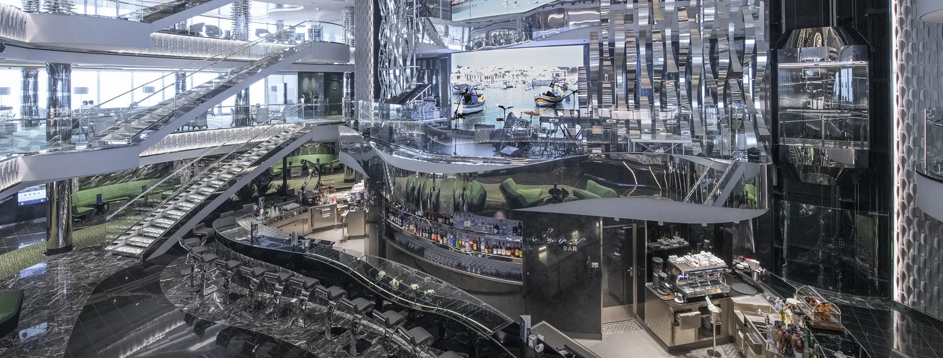 Modern multi-level bar with reflective surfaces, glass, and sleek design