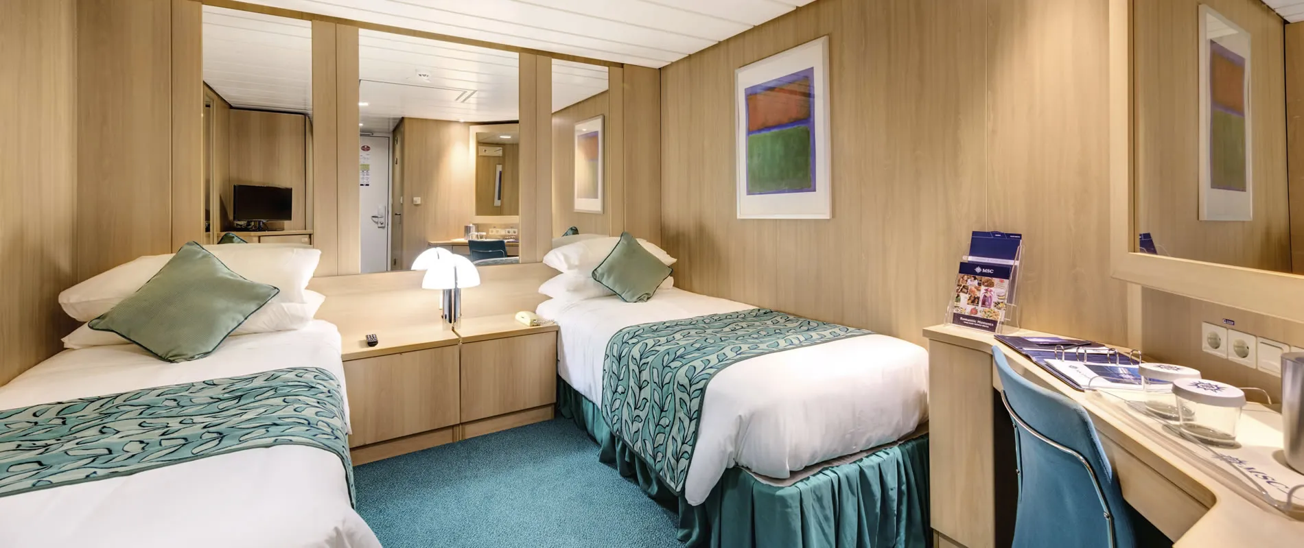 Cruise ship cabin with two beds, wooden walls, and teal accents