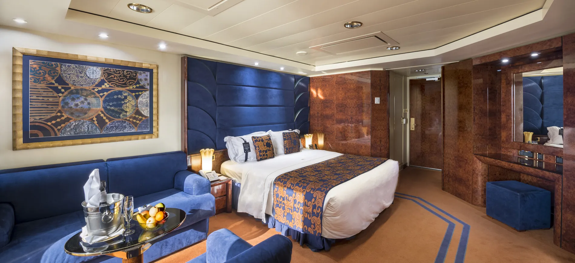 Luxury hotel room with blue decor, king bed, and champagne setup