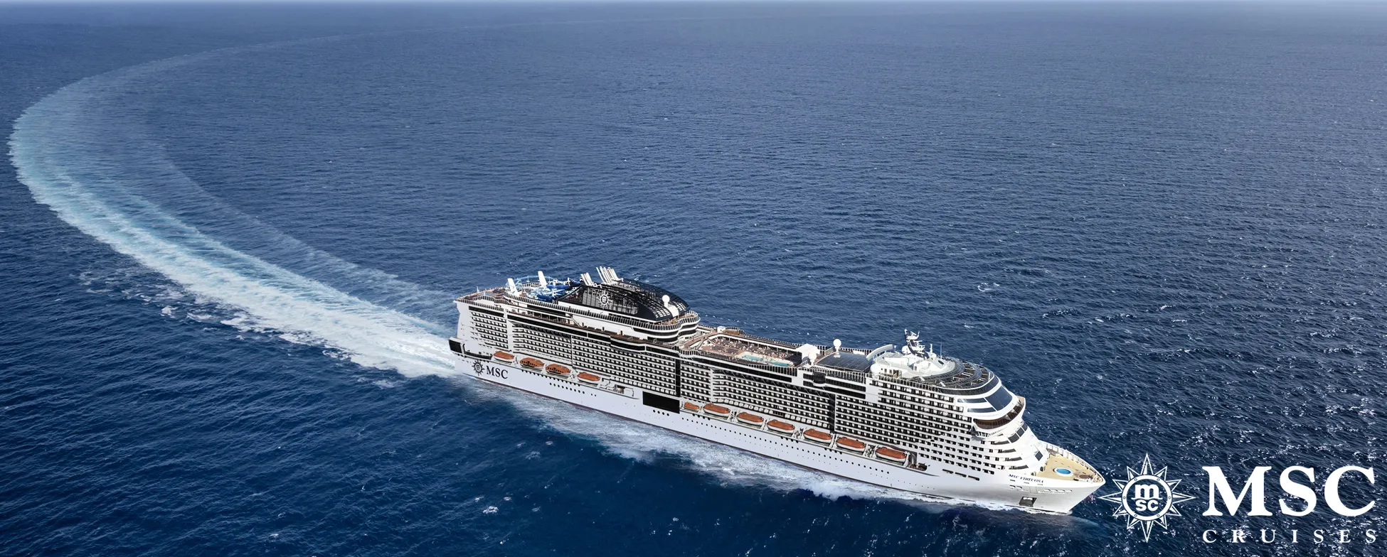 Large MSC cruise ship sailing on blue ocean, creating white wake