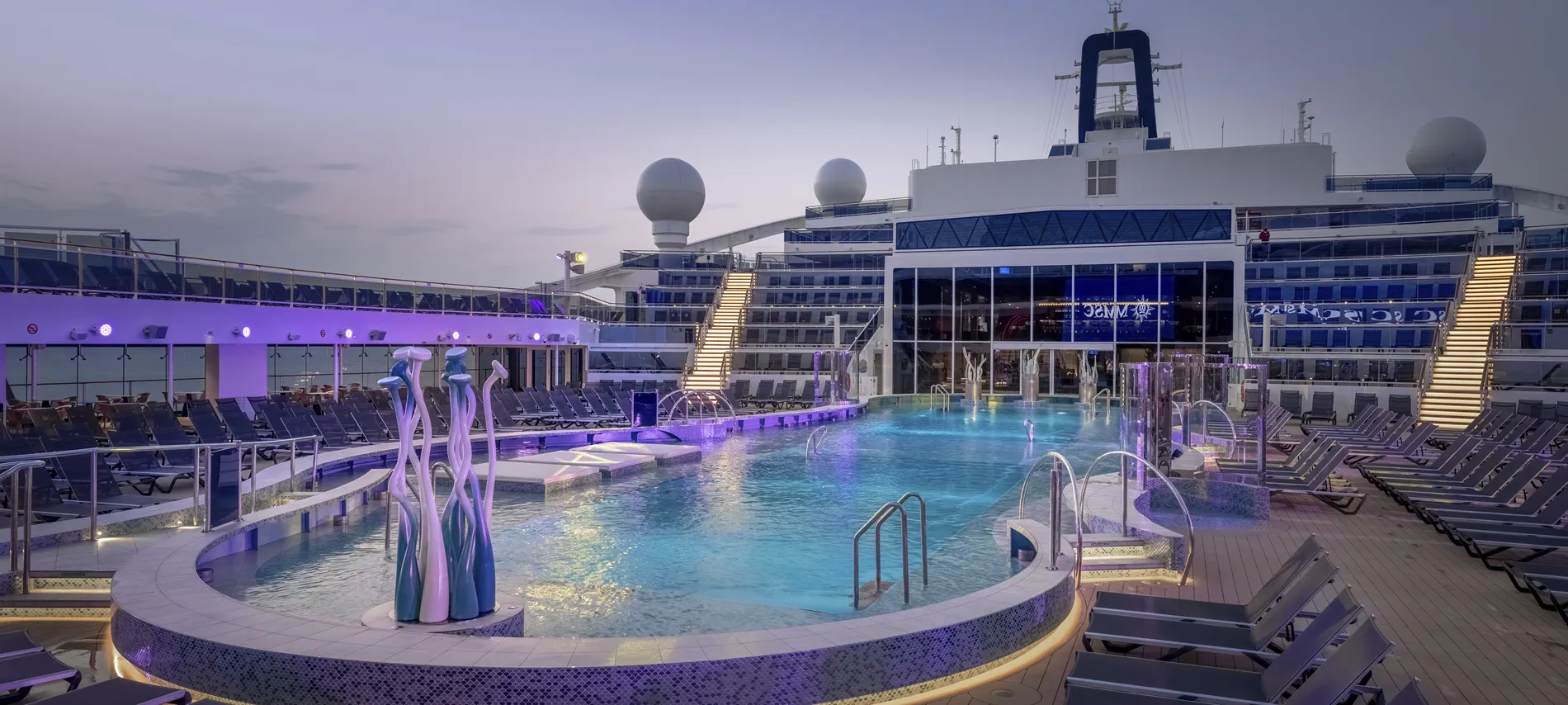 Luxurious cruise ship pool deck at dusk with purple lighting