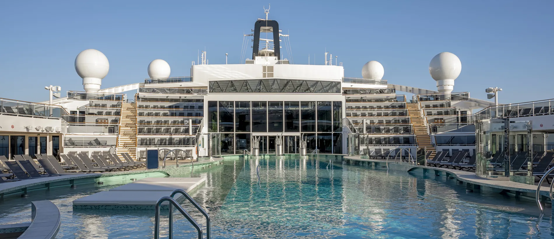 Luxurious cruise ship deck with swimming pool and sun loungers