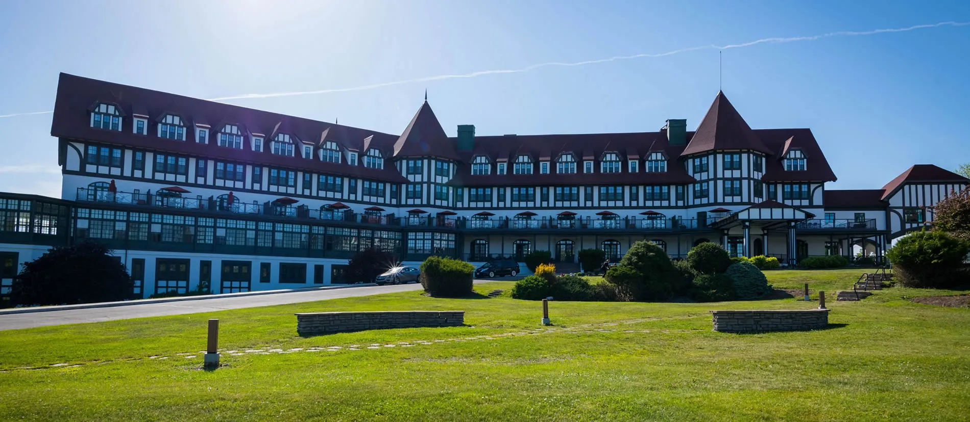 Large Tudor-style hotel with white and dark wood exterior on green lawn