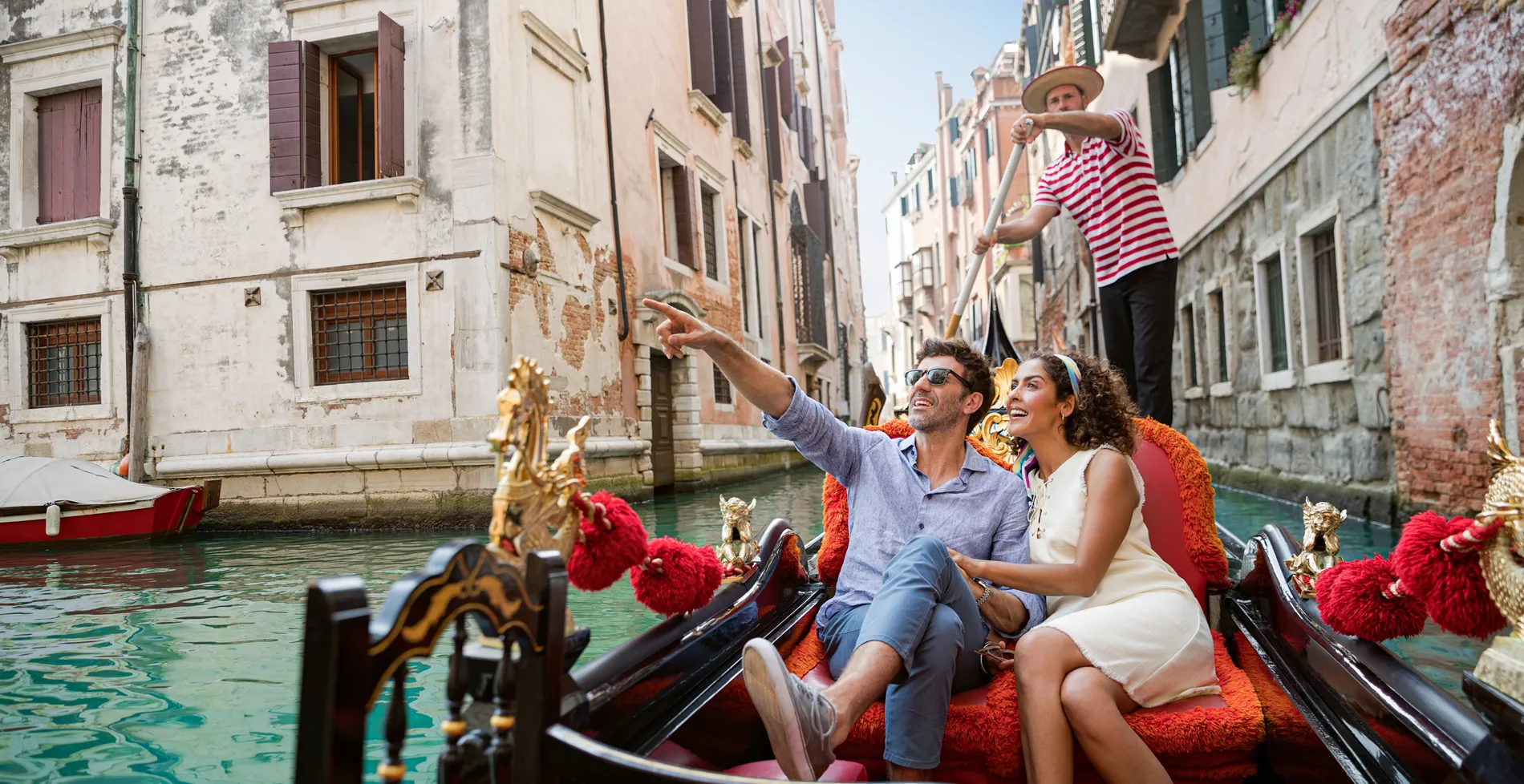 Couple enjoying romantic gondola ride through scenic Venice canal