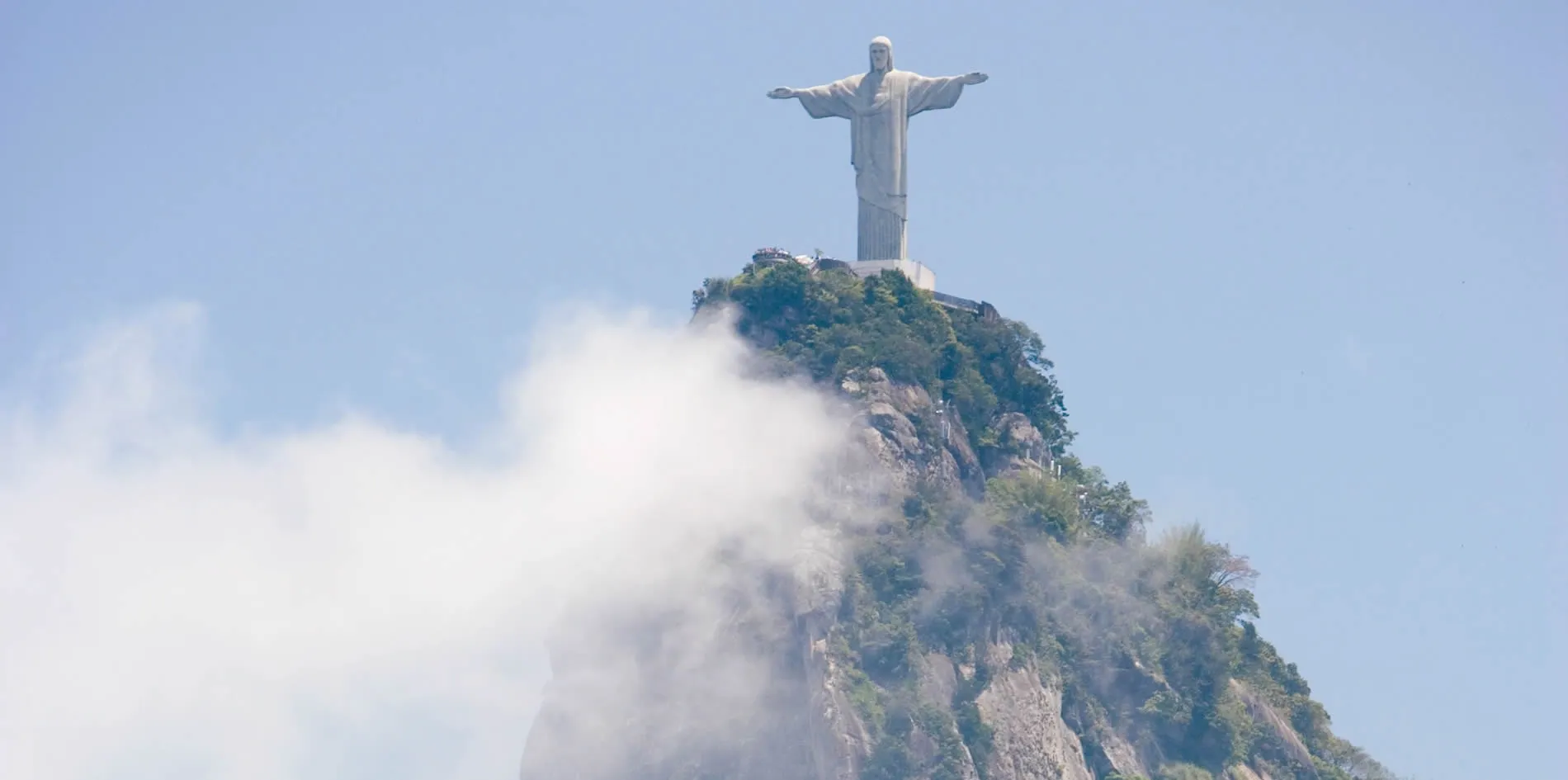 Christ the Redeemer statue overlooking Rio de Janeiro through misty clouds