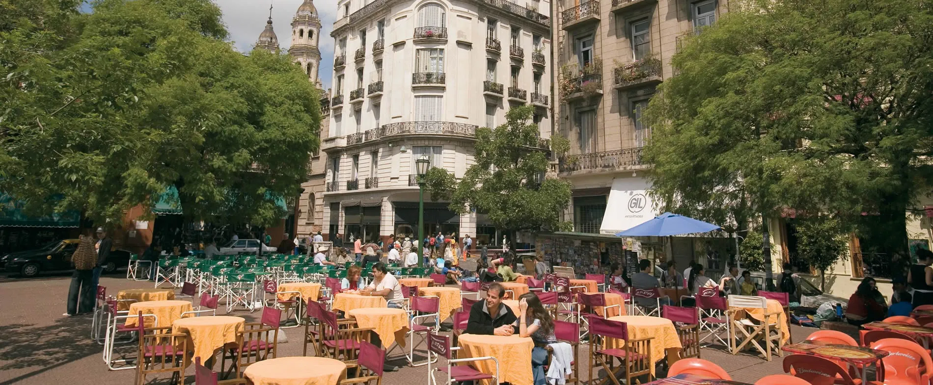 Outdoor cafe with colorful tables and chairs in a European-style city square