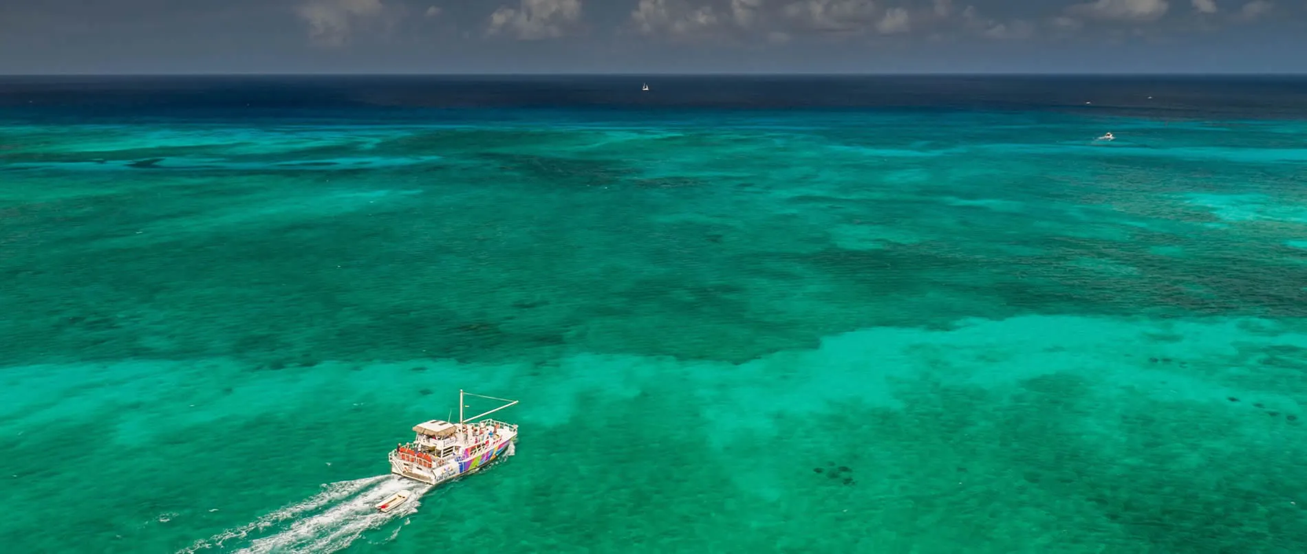 Colorful boat sailing on vibrant turquoise Caribbean waters