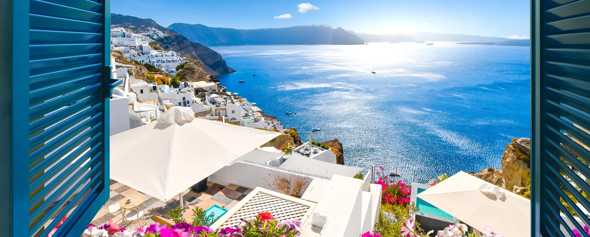 Picturesque Santorini view with white buildings, blue sea, and colorful flowers
