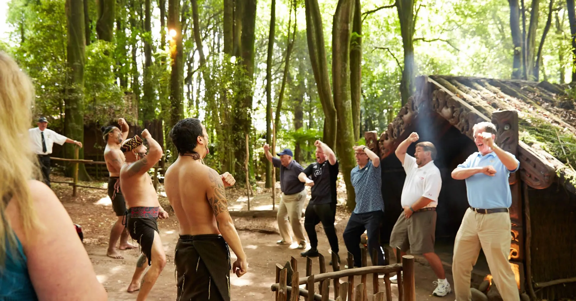 Maori warriors performing traditional haka dance for tourists in forest