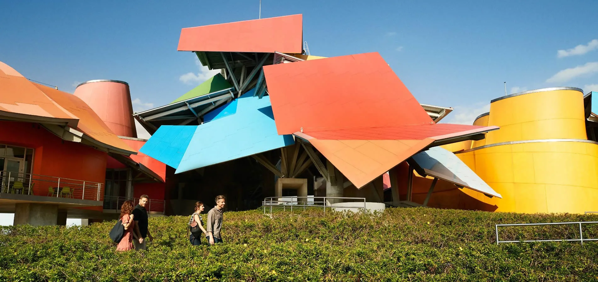 Colorful geometric building with angular shapes and people walking nearby
