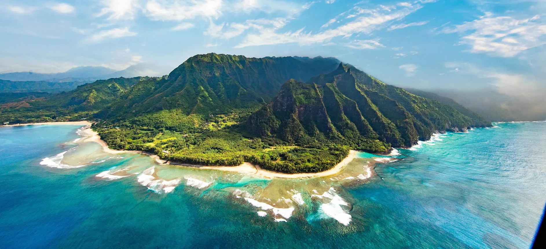 Aerial view of lush Hawaiian island with turquoise waters and green mountains