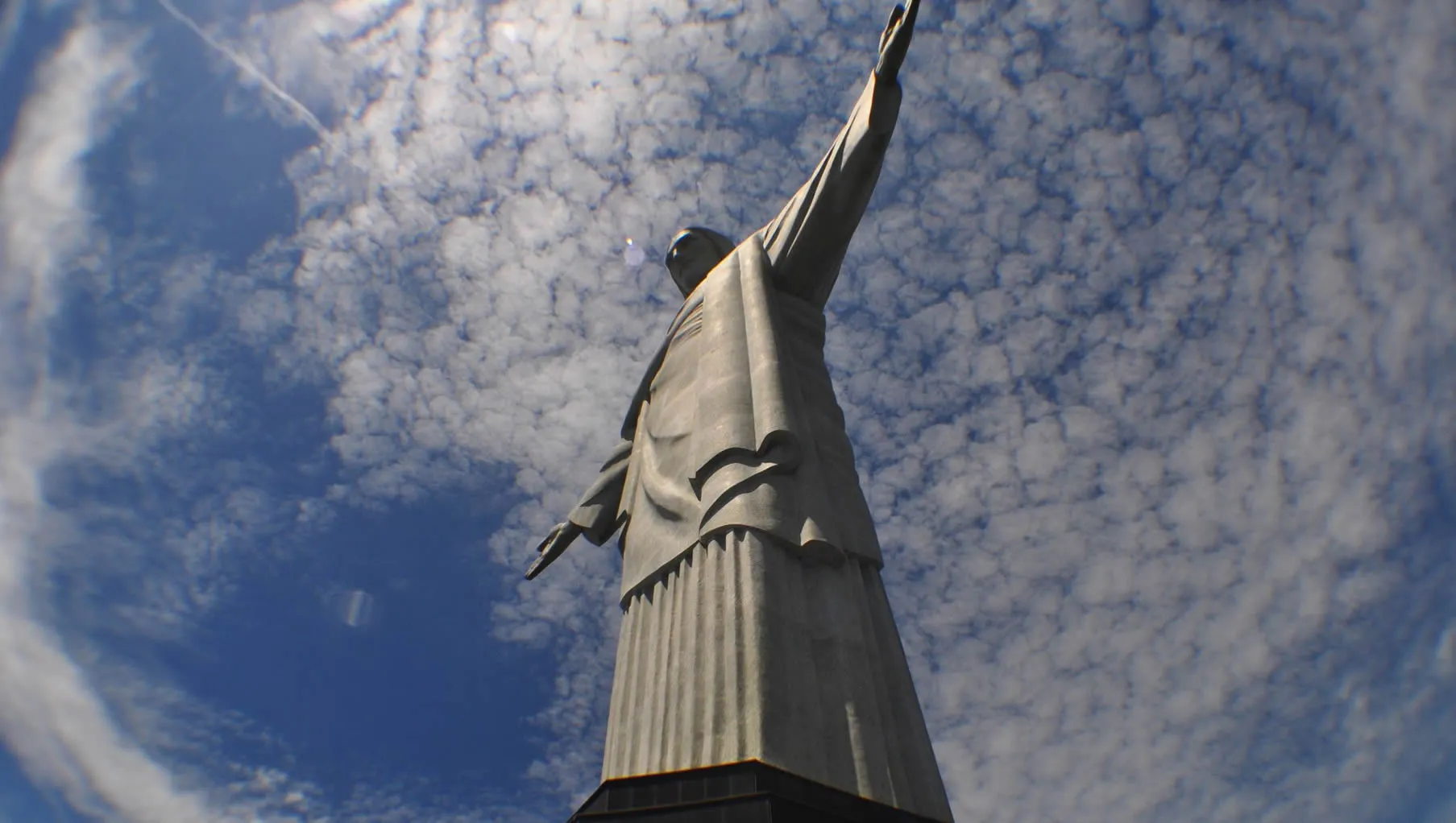 Christ the Redeemer statue towering against cloudy blue sky in Rio
