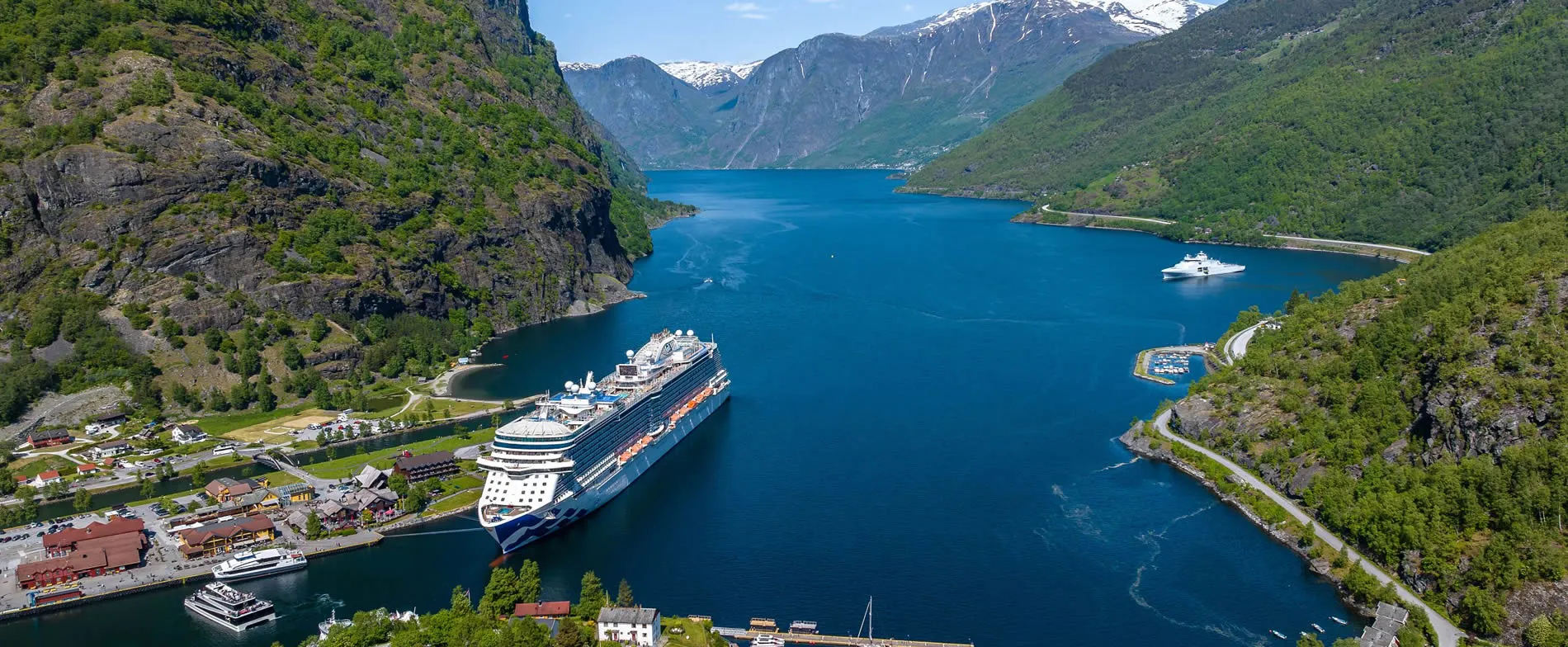 Cruise ships docked in scenic Norwegian fjord surrounded by mountains
