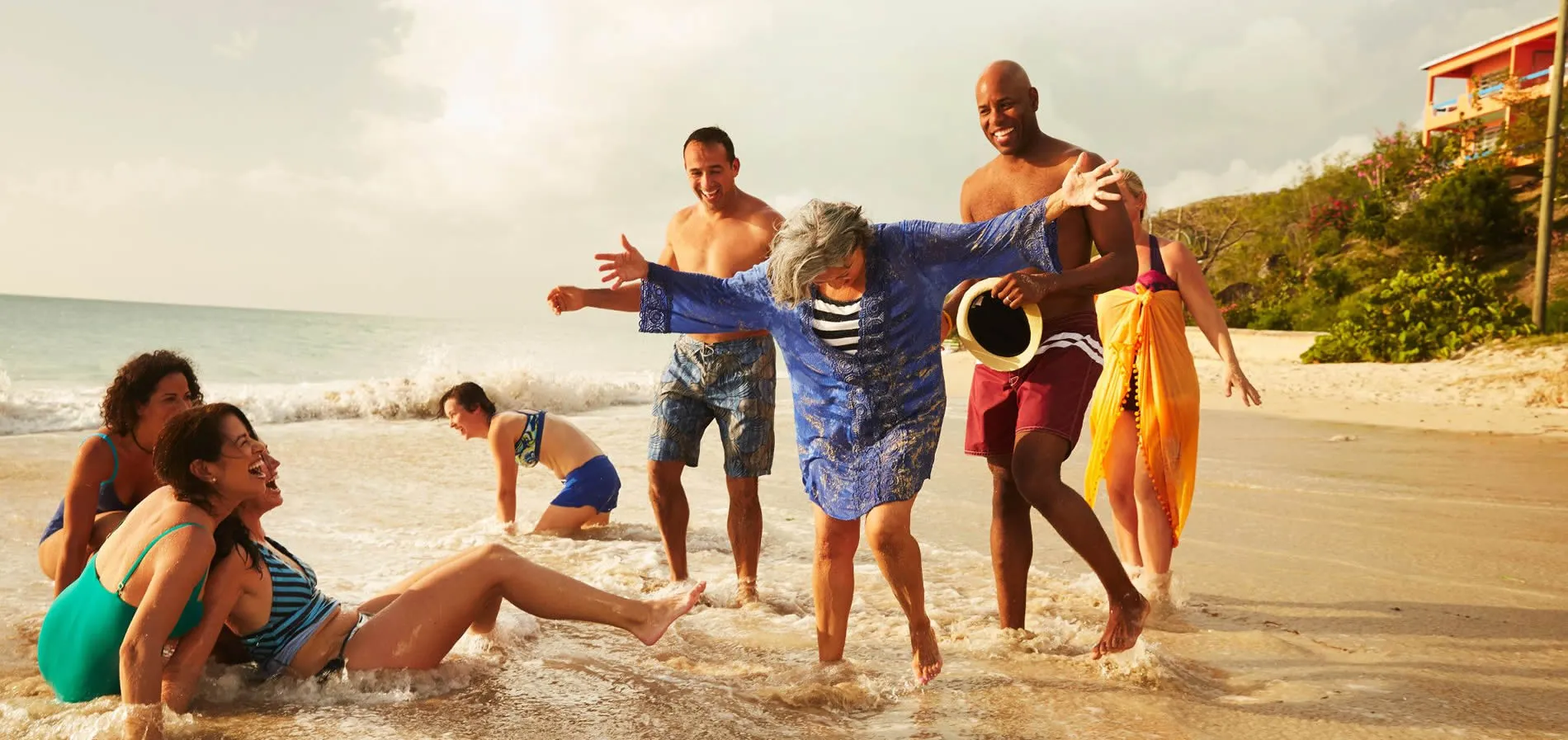 Diverse group of friends enjoying playful moment on sunny beach