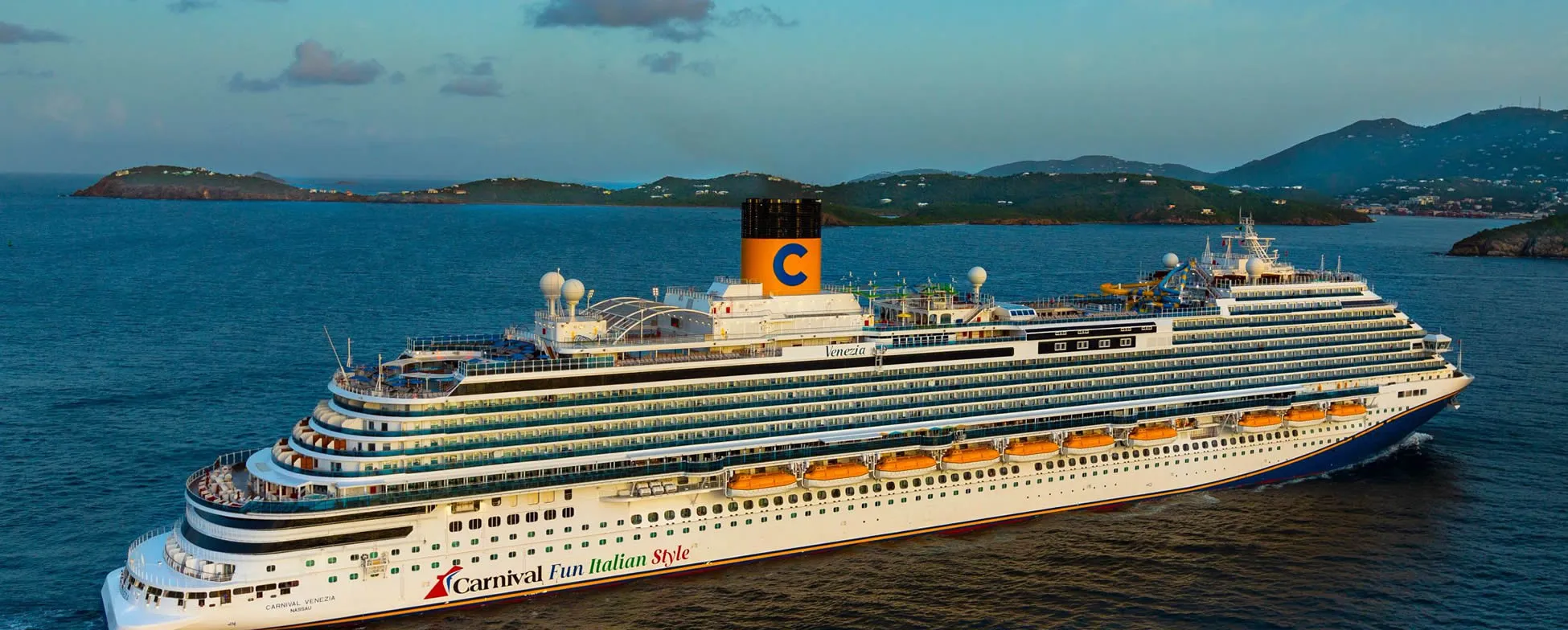 Large Carnival cruise ship Venezia sailing near mountainous islands