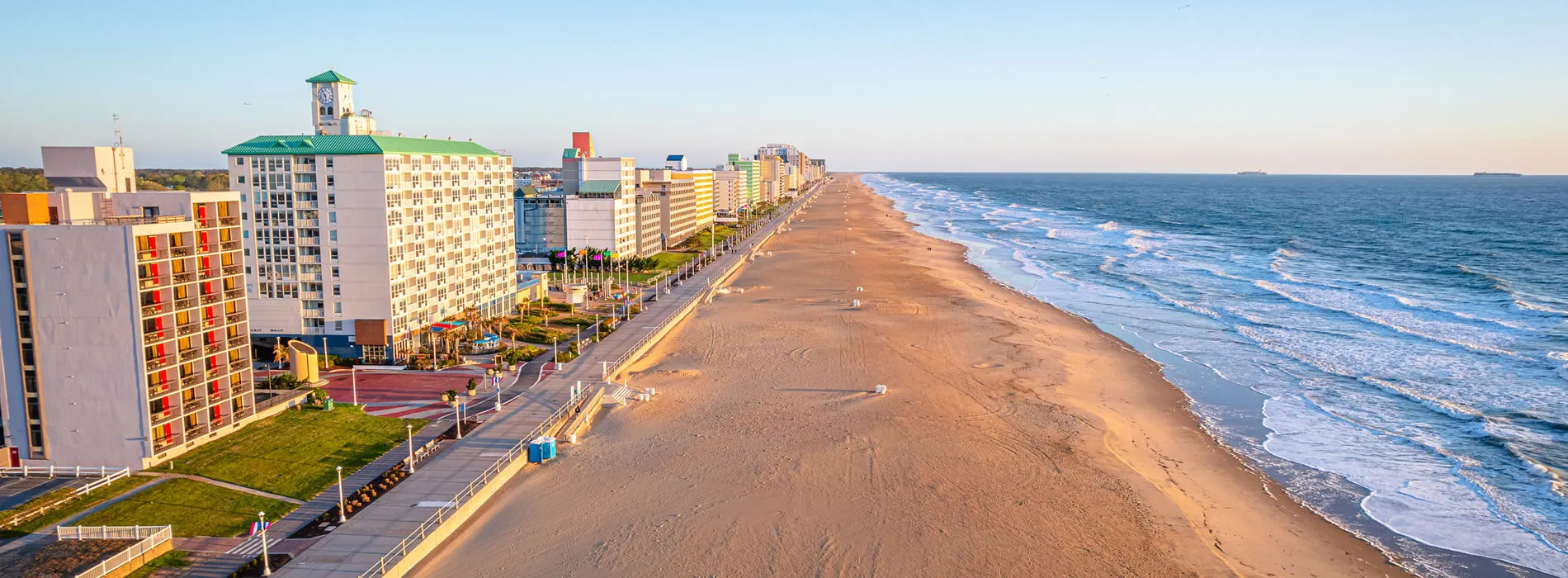 Virginia Beach oceanfront with hotels and wide sandy beach at sunrise