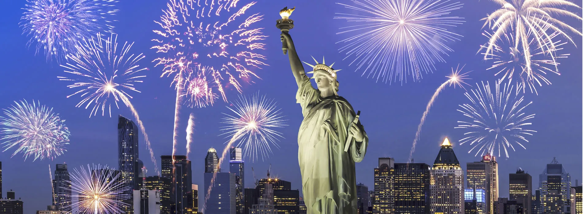 Statue of Liberty with New York City skyline and fireworks at night