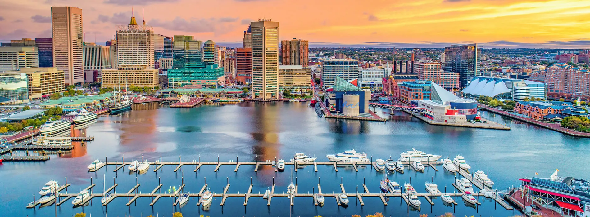 Baltimore Inner Harbor skyline with marina and colorful sunset